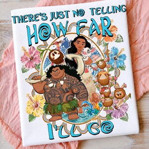 Op de afbeelding: Een wit t-shirt met een kleurrijke afbeelding van Moana, Maui, Pua en Heihei, omringd door tropische hibiscusbloemen. De tekst "THERE'S JUST NO TELLING HOW FAR I'LL GO" staat in dikke blauwe letters in een cirkelvormig decoratief kader.