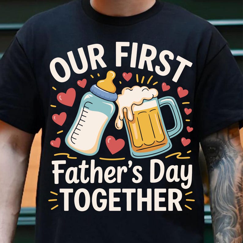 May include: Black t-shirt with a graphic design of a baby bottle and a beer mug. The text "Our First Father's Day Together" is printed on the shirt.