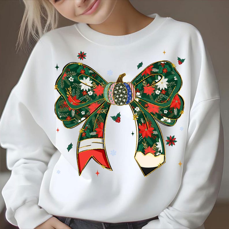 May include: White sweatshirt featuring a large bow design with a pumpkin center. The bow is decorated with red poinsettias, white flowers, and green leaves. The pumpkin has a patchwork design with American flag accents. Festive apparel.