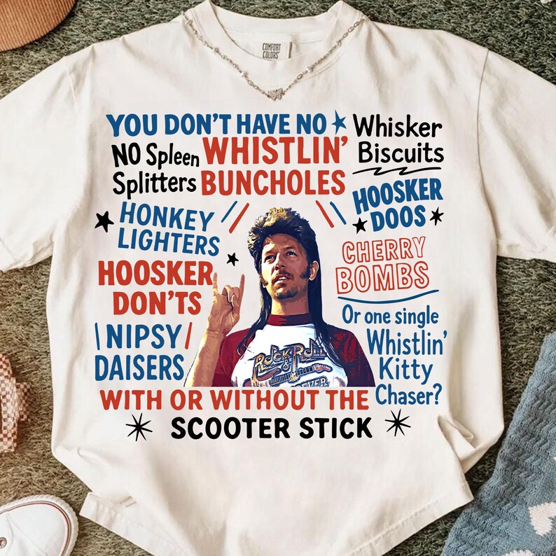 May include: White t-shirt with a graphic featuring a man and text in red and blue. The text includes phrases like "You Don't Have No Whisker" and "Scooter Stick". The shirt has a crew neck and short sleeves.