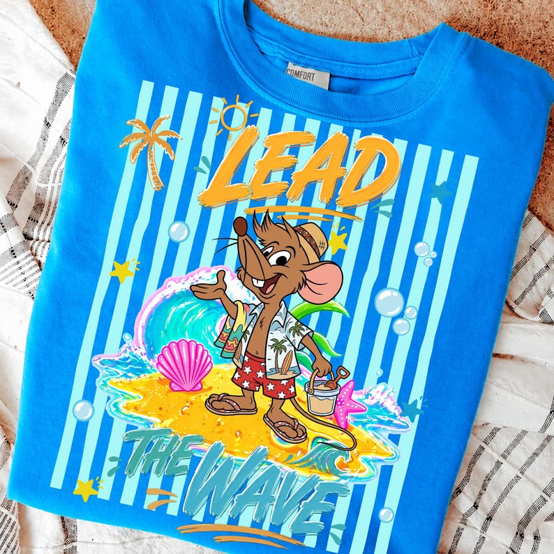 May include: A blue sweatshirt with a cartoon mouse in beach attire, the words "LEAD THE WAVE" are printed on the front. The design includes a wave, palm tree, and seashells. The shirt has a crew neck and a tag that says "COMFORT".