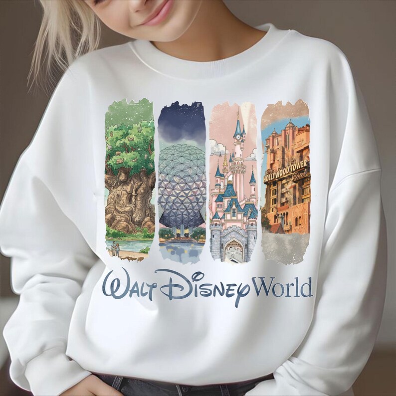 May include: White sweatshirt featuring four vertical panels with illustrations of Disney World landmarks. The panels include the Tree of Life, Spaceship Earth, Cinderella Castle, and the Hollywood Tower Hotel. The words "Walt Disney World" are printed in a script font.
