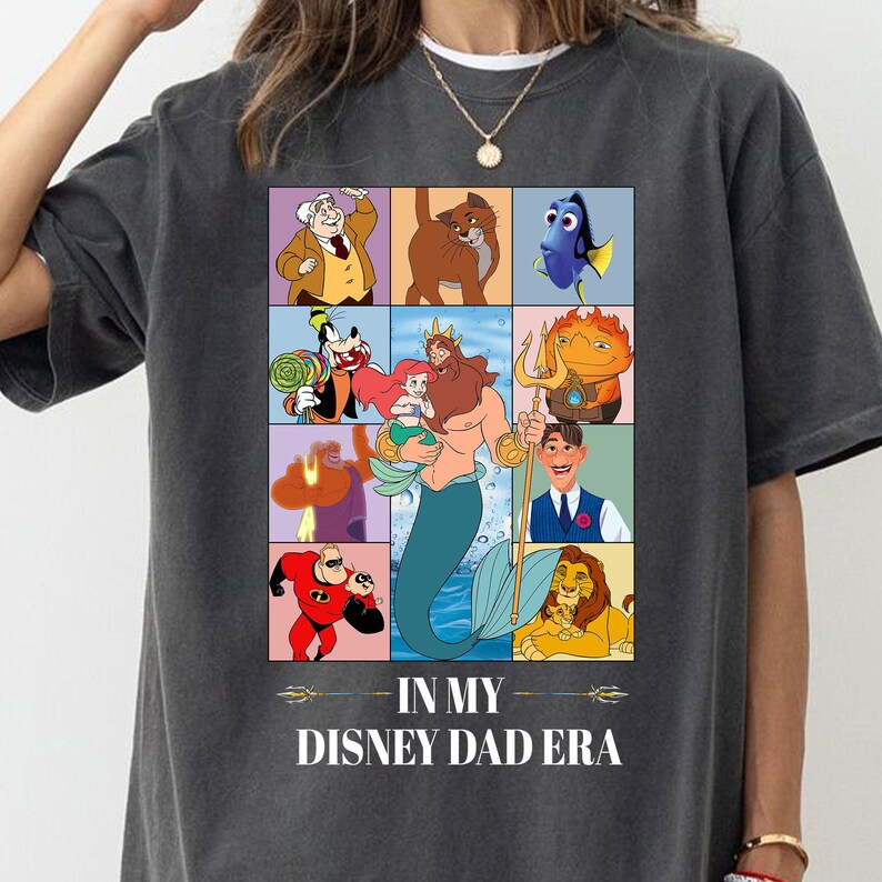 Pu&ograve; includere: T-shirt grigio scuro con una griglia colorata di personaggi Disney, tra cui Pippo, Ariel e Simba. La frase "IN MY DISNEY DAD ERA" &egrave; stampata in bianco sotto. La maglietta &egrave; realizzata in un materiale morbido.