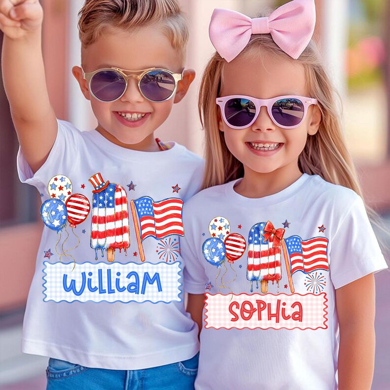May include: Two children wearing white t-shirts with patriotic designs. The shirts feature an American flag popsicle, balloons, and the names "William" and "Sophia". Both children are wearing sunglasses and smiling.