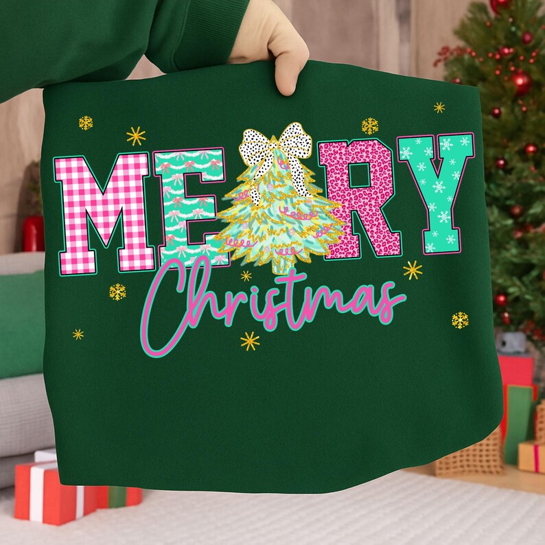 Puede incluir: Un coj&iacute;n verde oscuro con las palabras "MERRY Christmas" en rosa, turquesa y blanco. La letra "M" es rosa a cuadros, la "E" es turquesa con copos de nieve blancos y la "R" es rosa con estampado de leopardo. Un gr&aacute;fico de &aacute;rbol de Navidad est&aacute; en el centro.