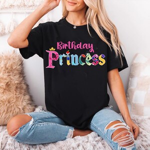 May include: Black t-shirt with a pink "Birthday Princess" graphic featuring colorful Disney princess icons.
