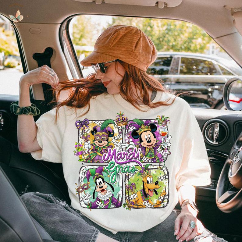 May include: Cream-colored sweatshirt featuring four square designs with Disney characters in Mardi Gras attire. The word "Mardi Gras" is in a purple script font. The characters include Mickey, Minnie, Goofy, and Pluto.
