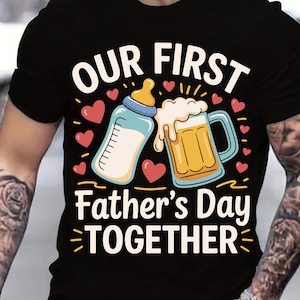 May include: Black t-shirt with a graphic of a baby bottle and a beer mug clinking together. The text "Our First Father's Day Together" is printed below the graphic.