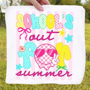 May include: White square towel with a colorful graphic that reads "SCHOOL'S OUT FOR SUMMER". The text is in various colors and fonts, with checkered and patterned details. Pink and white striped background.