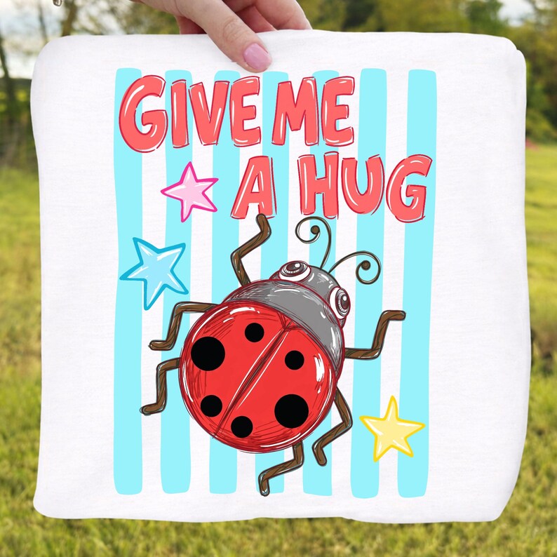Pu&ograve; includere: Tessuto quadrato bianco con una coccinella dei cartoni animati e la scritta "GIVE ME A HUG" in rosso. La coccinella &egrave; rossa con pois neri e una testa grigia. Stelle blu e rosa sono sparse intorno alla coccinella, con strisce verticali blu sullo sfondo.