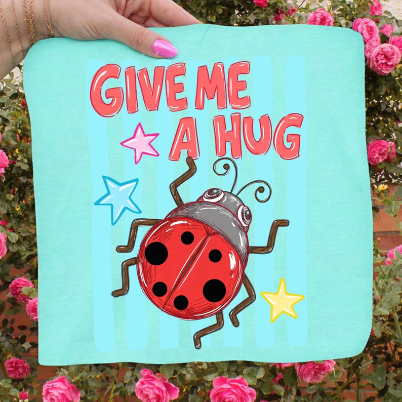 Pu&ograve; includere: Un tessuto quadrato azzurro con la scritta "GIVE ME A HUG" in rosso, insieme a una coccinella dei cartoni animati e grafiche a stella. La coccinella &egrave; rossa con pois neri e una testa grigia. Lo sfondo ha strisce verticali blu.