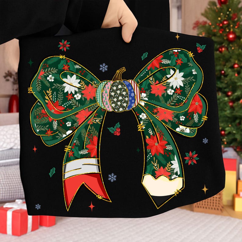 May include: Black decorative bow with a festive design. The bow features a pumpkin-shaped center with various patterns and a green ribbon adorned with red poinsettias, white flowers, and gold accents. The bow is held up by a person.