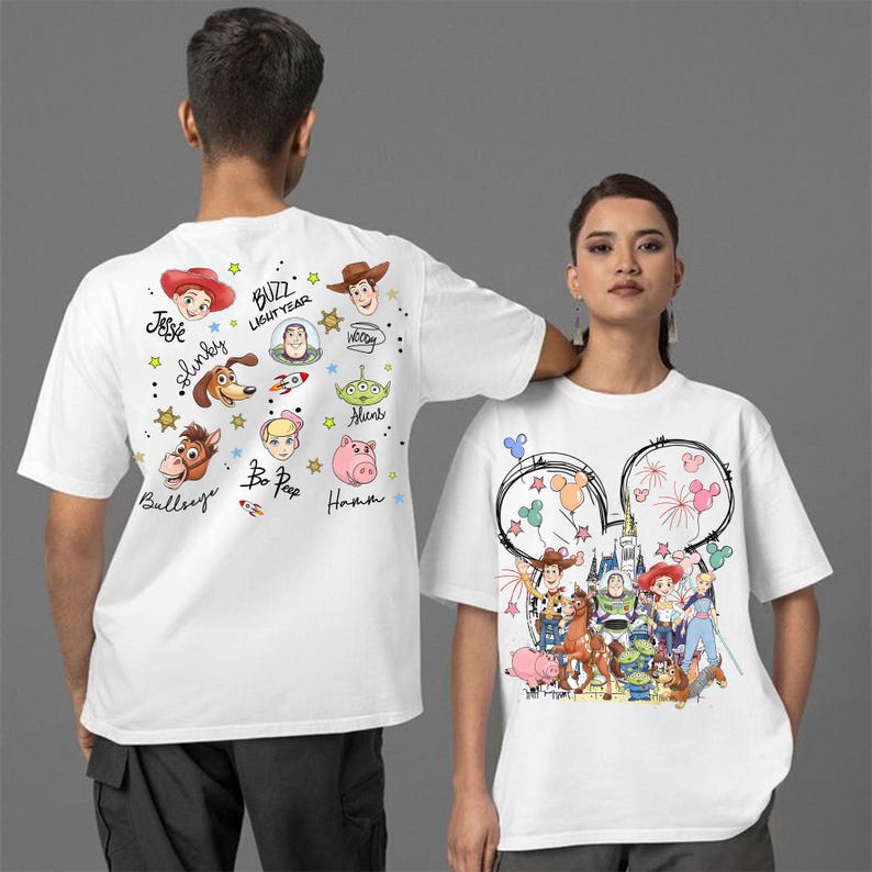May include: White t-shirts with Disney's Toy Story characters. One shirt has character faces and names, the other a Disney castle and characters. Both have short sleeves. The shirts are made of a soft material.