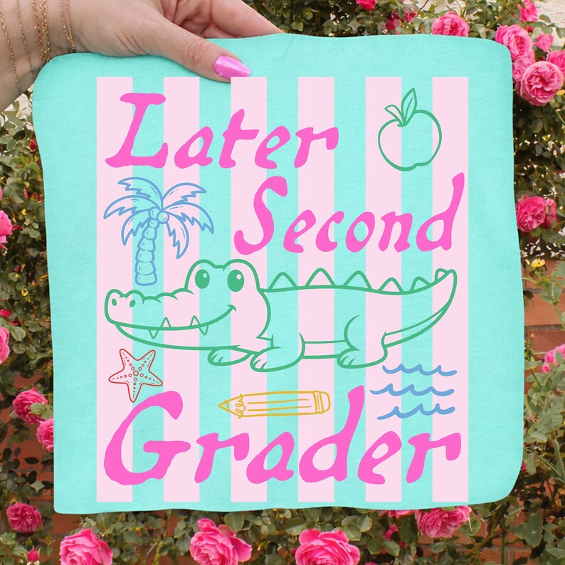May include: A teal and pink sign with the words "Later Second Grader" in pink script. The sign features a cartoon alligator, palm tree, apple, starfish, pencil, and waves.
