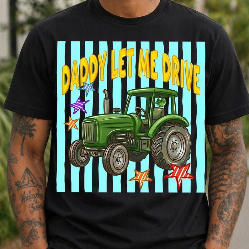 Pu&ograve; includere: T-shirt nero con grafica di un trattore verde e la scritta "DADDY LET ME DRIVE" in giallo. Il design include strisce verticali blu e nere e stelle colorate, creando un design giocoso e accattivante.
