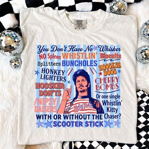 Pu&ograve; includere: T-shirt color crema con una grafica raffigurante un uomo e del testo. Il testo include frasi come "You Don't Have No Whisker" e "Scooter Stick". Il design &egrave; in blu, rosso e bianco.