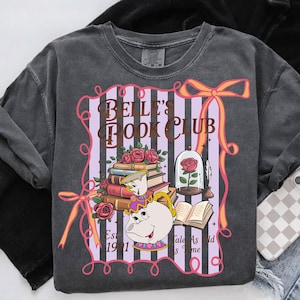 May include: Dark grey sweatshirt with a graphic design. The design includes the text "BELLE'S BOOK CLUB", books, roses, and a teapot. A rose is in a glass dome, with the phrase "Tale As Old As Time" below.