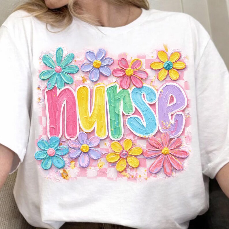 May include: White t-shirt featuring the word "nurse" in colorful, textured letters, surrounded by pastel-colored flowers. The background has a pink and white checkered pattern. The flowers are in shades of blue, pink, yellow, and purple.