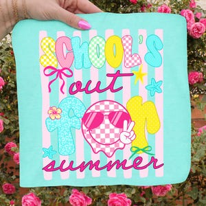 May include: A turquoise square textile with the words "SCHOOL'S OUT FOR SUMMER" in a playful font. The design includes pink stripes, a smiley face wearing sunglasses, stars, and bows. The text and graphics are in various colors.