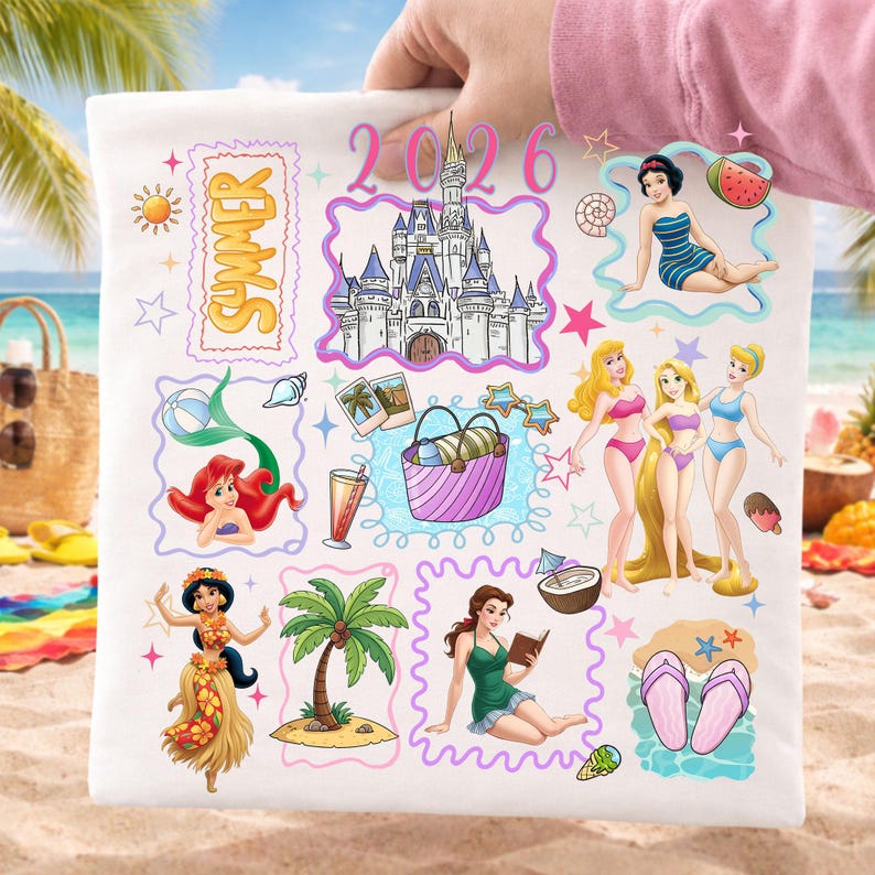 May include: White tote bag featuring colorful illustrations of Disney princesses, a castle, and summer-themed elements. The design includes the word "Summer" and the year "2026". The bag is held up against a beach background.