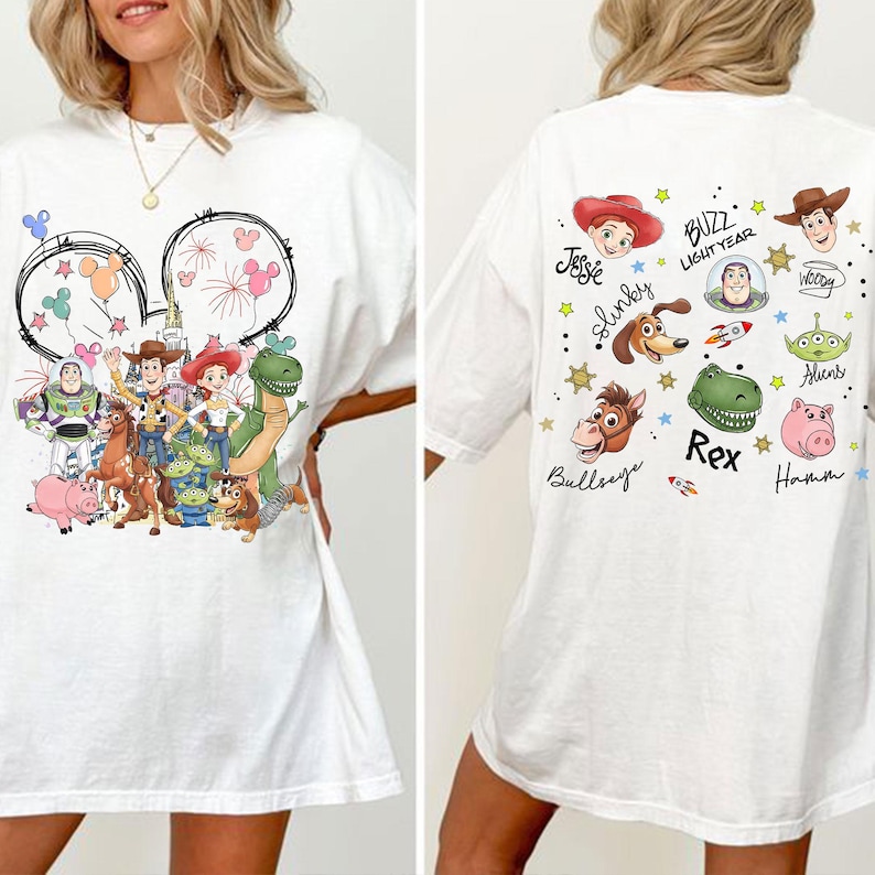 Może przedstawiać: Biała koszulka z kolorową grafiką postaci z Toy Story Disneya z przodu i z tyłu. Przedni wz&oacute;r zawiera uszy Myszki Miki z fajerwerkami i postaciami takimi jak Buzz Lightyear, Woody i Jessie. Tył ma imiona postaci.