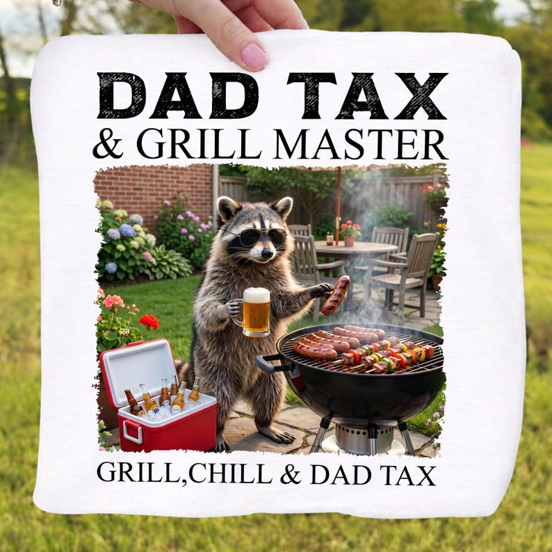 May include: White square towel with the text "DAD TAX & GRILL MASTER" and "GRILL, CHILL & DAD TAX". A raccoon wearing sunglasses is grilling sausages and holding a beer. A red cooler with beer bottles is in the image.