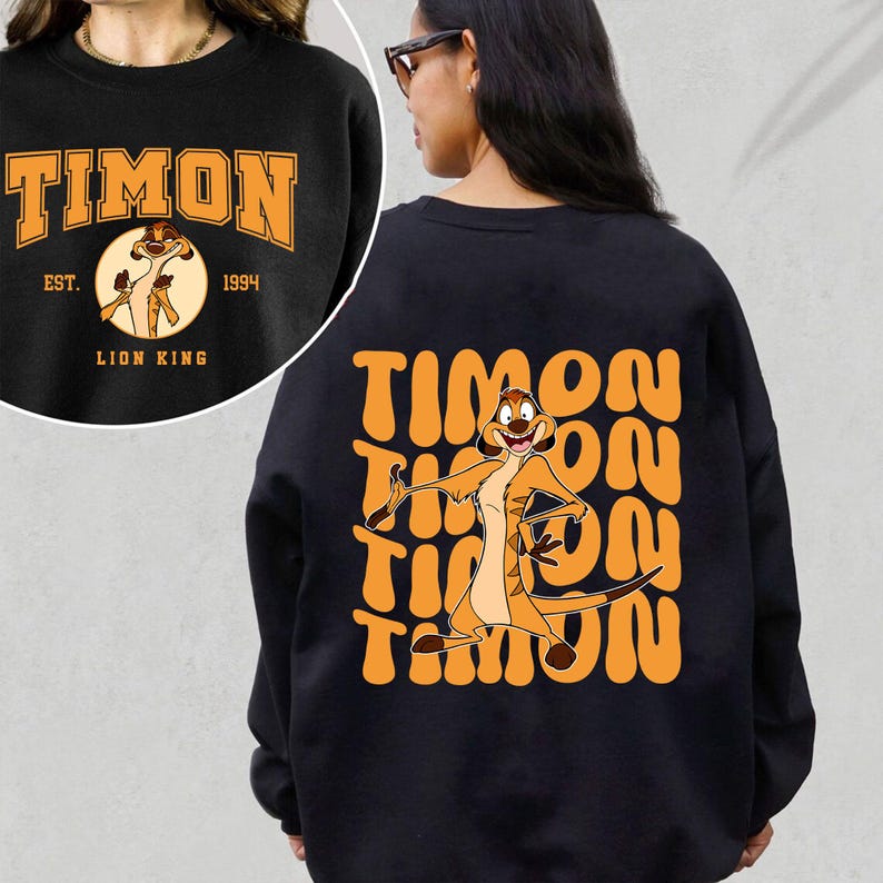 May include: Black sweatshirt with a graphic of Timon from The Lion King. The front of the sweatshirt has the text "Timon" with "Est. 1994" and "Lion King" underneath. The back of the sweatshirt has a repeated graphic of Timon with the text "Timon" in a retro font.