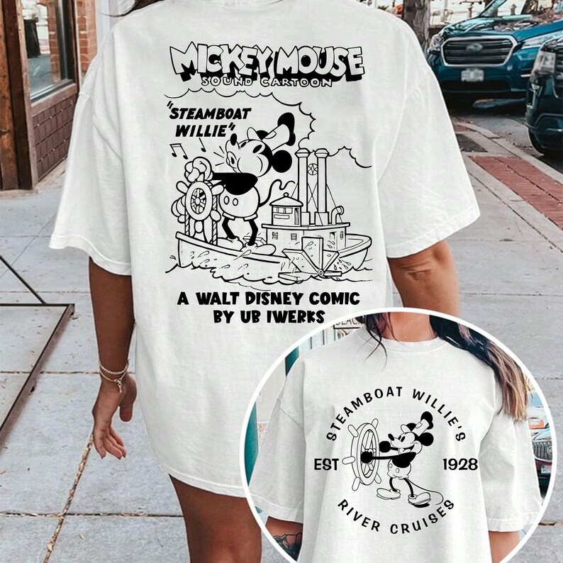 May include: White t-shirt featuring a black and white illustration of Mickey Mouse on a steamboat. The text "Mickey Mouse Sound Cartoon" is at the top of the shirt. The text "Steamboat Willie" is below the illustration. The text "A Walt Disney Comic by Ub Iwerks" is at the bottom of the shirt.