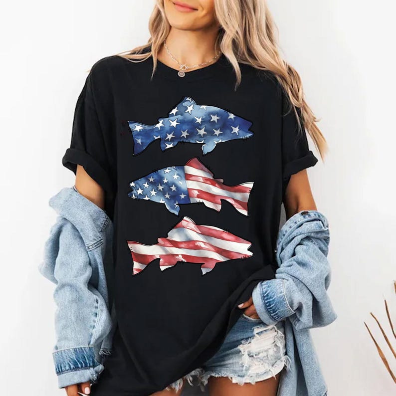 May include: Black t-shirt with three fish designs. The top fish is blue with white stars, the middle fish has a blue and white star pattern on the top half and red and white stripes on the bottom half, and the bottom fish has red and white stripes.