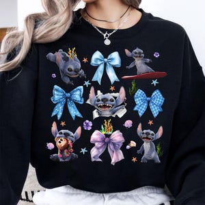 May include: Black sweatshirt featuring a repeating pattern of the character Stitch from the animated film Lilo & Stitch. The design includes Stitch in various poses, surrounded by blue bows, starfish, and floral accents.