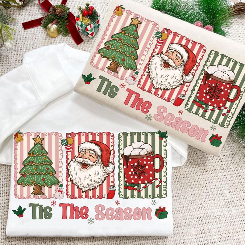Puede incluir: Dos sudaderas blancas con un dise&ntilde;o navide&ntilde;o. Una sudadera presenta un &aacute;rbol de Navidad, Pap&aacute; Noel y una taza de chocolate caliente con el texto "Tis The Season". La otra sudadera tiene el mismo dise&ntilde;o.