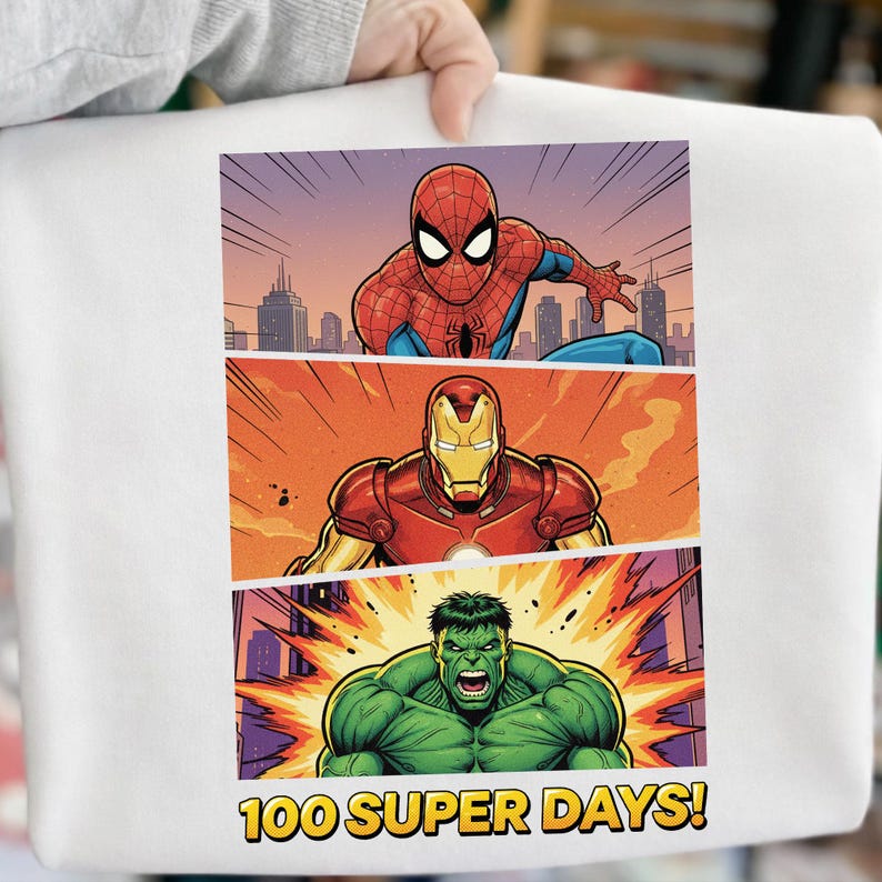 May include: White sweatshirt featuring a comic book style design with Spider-Man, Iron Man, and the Hulk. The text "100 SUPER DAYS!" is displayed at the bottom of the graphic. The superheroes are set against a cityscape background.