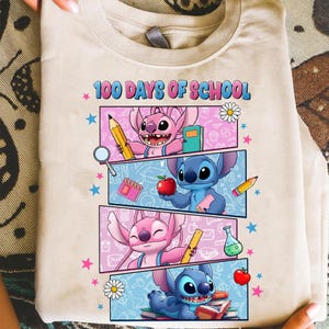 May include: Beige t-shirt with the text "100 Days of School" and a colourful graphic. The graphic features cartoon characters, pencils, books, and other school-related elements. The design is set against a light blue and pink background.