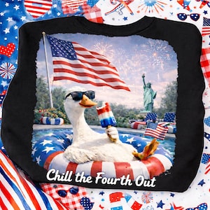 Könnte beinhalten: Schwarzes Sweatshirt mit einer Grafik einer Gans mit Sonnenbrille, die in einem Pool schwimmt. Im Hintergrund sind die amerikanische Flagge und die Freiheitsstatue zu sehen. Text: "Chill the Fourth Out."