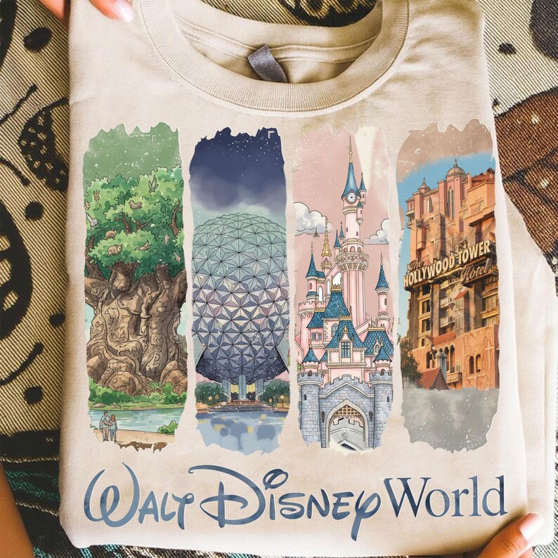 May include: A beige t-shirt featuring four colorful illustrations of Walt Disney World landmarks. The shirt includes images of the Tree of Life, Spaceship Earth, Cinderella Castle, and the Hollywood Tower Hotel. The words "Walt Disney World" are printed at the bottom.