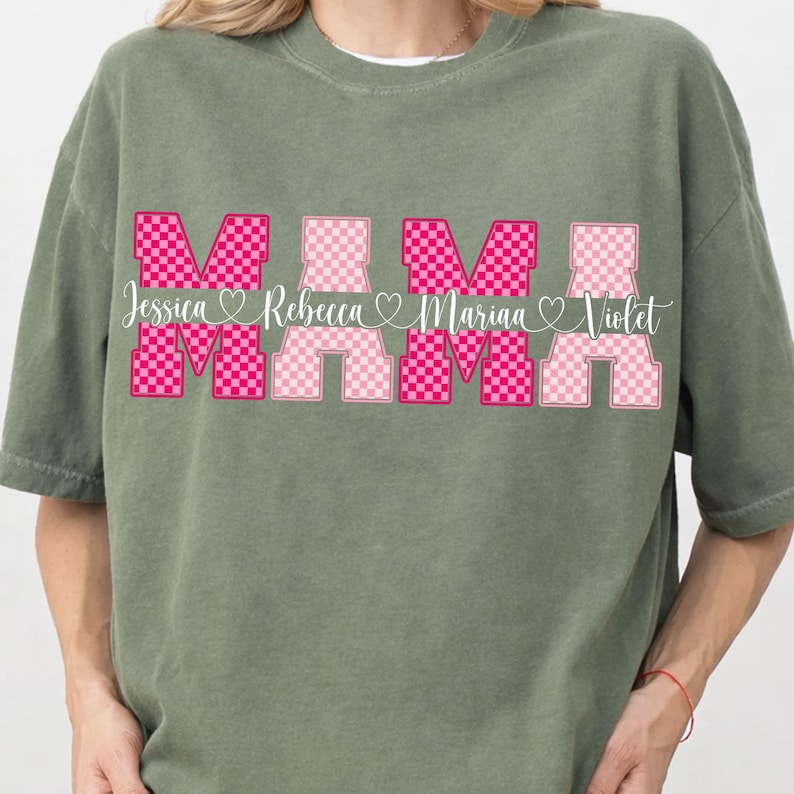 May include: Sage green t-shirt with the word "MAMA" in a pink checkered design. The names Jessica, Rebecca, Marina, and Violet are printed below the word "MAMA" in a cursive font.