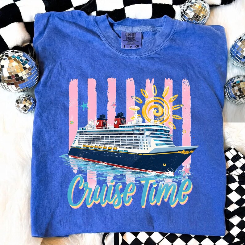 May include: A blue Comfort Colors sweatshirt with a cruise ship graphic and the words "Cruise Time." The design includes a sun, pink stripes, and stars. The shirt is a small size.