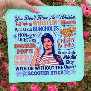 Pu&ograve; includere: Un tessuto quadrato azzurro con una grafica raffigurante un uomo con i capelli lunghi e del testo. Il testo include frasi come "You Don't Have No Whisker" e "Scooter Stick". L'uomo indossa una camicia a righe.
