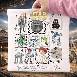 Peut inclure: Taie d'oreiller blanche sur le thème de Star Wars, avec diverses illustrations de personnages dans des cadres en forme de timbre. Comprend le texte "STAR WARS" et "The Most Magical Place on Earth". L'année "2026" est également imprimée.