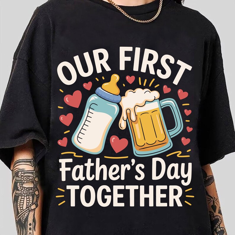 May include: Black t-shirt with the text "Our First Father's Day Together" in white. The design includes a baby bottle and a beer mug with hearts and stars.