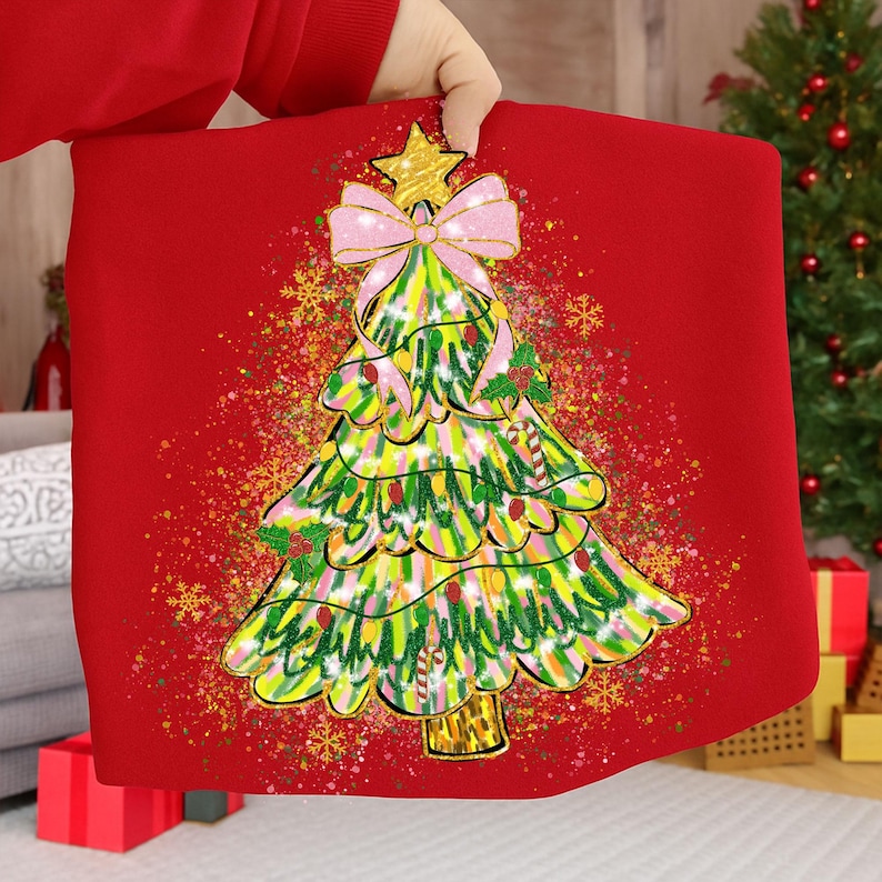 May include: A red Christmas-themed pillow with a colorful, whimsical Christmas tree design. The tree features a gold star, pink bow, and candy cane accents. The background has a speckled effect with gold snowflakes.