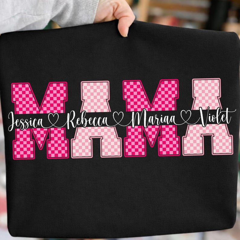 May include: Black sweatshirt with the word "MAMA" in pink checkered letters. Below the word "MAMA" are the names Jessica, Rebecca, Mariaa, and Violet in white script font, each separated by a heart symbol.