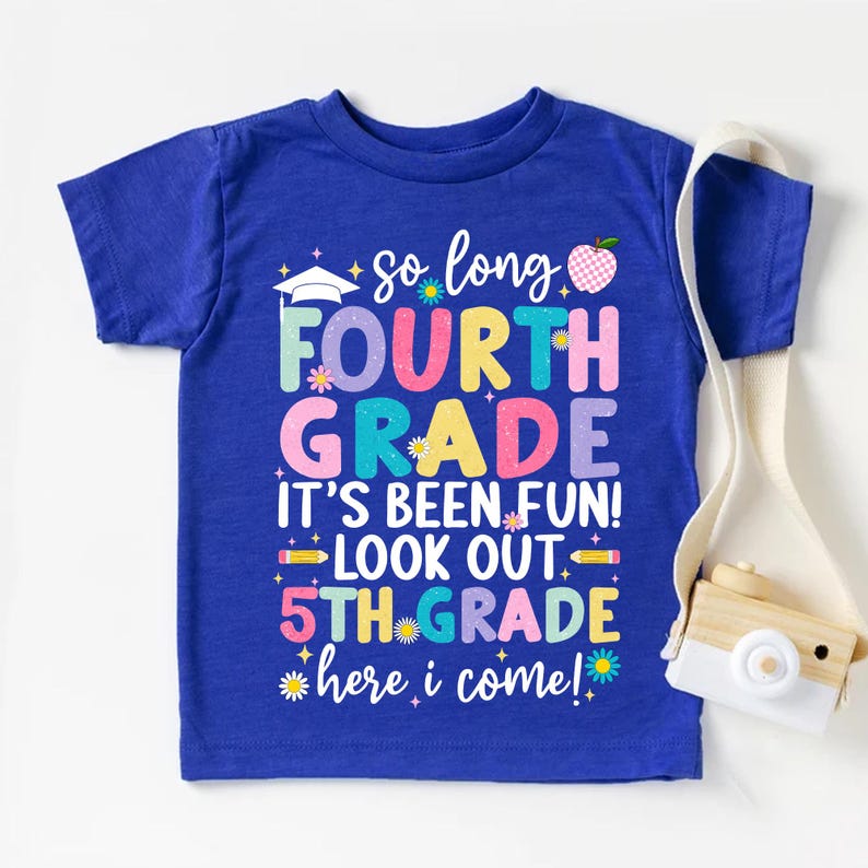 Puede incluir: Camiseta azul con el texto: "So long Fourth Grade, It's been fun! Look out 5th Grade, here I come!" Presenta un gorro de graduaci&oacute;n, una manzana y detalles florales. Un dise&ntilde;o colorido para el regreso a clases.