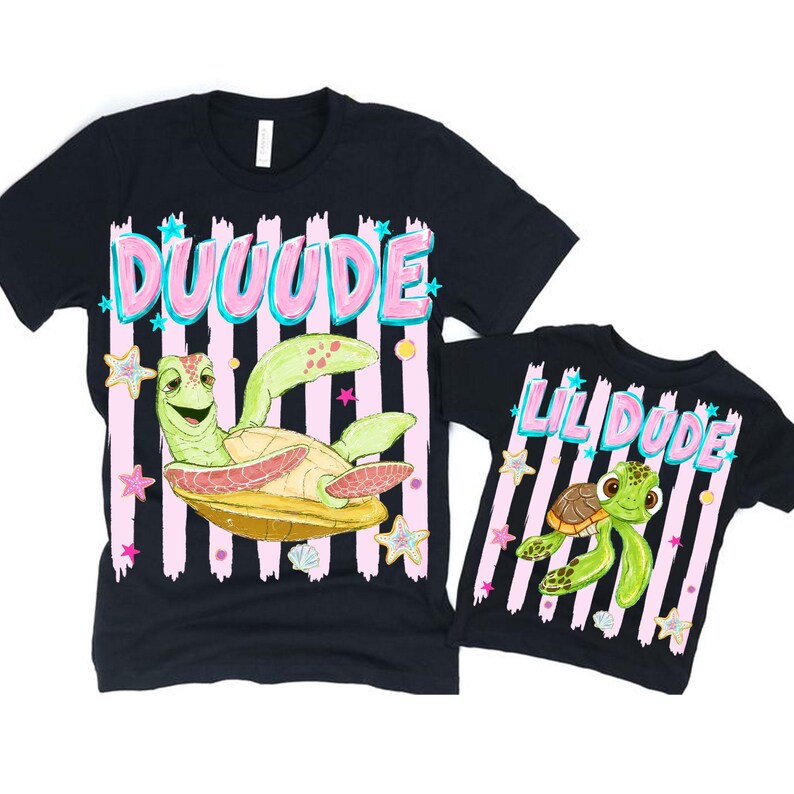 May include: Two black t-shirts with matching designs. One shirt says "DUUUUDE" above a cartoon turtle, and the other says "LIL DUDE" with a smaller turtle graphic. Both shirts have pink and white striped backgrounds.