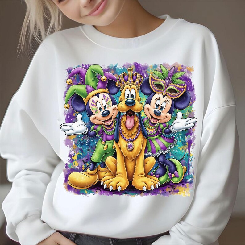 May include: White sweatshirt featuring Mickey Mouse, Minnie Mouse, and Pluto in Mardi Gras attire. Mickey and Minnie wear festive outfits and masks, while Pluto sports a crown and necklace. The design has a colorful, watercolor-like background.