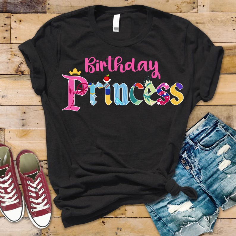 May include: Black t-shirt with the text "Birthday Princess" in pink and colorful letters. The letters are decorated with images of Disney princesses.
