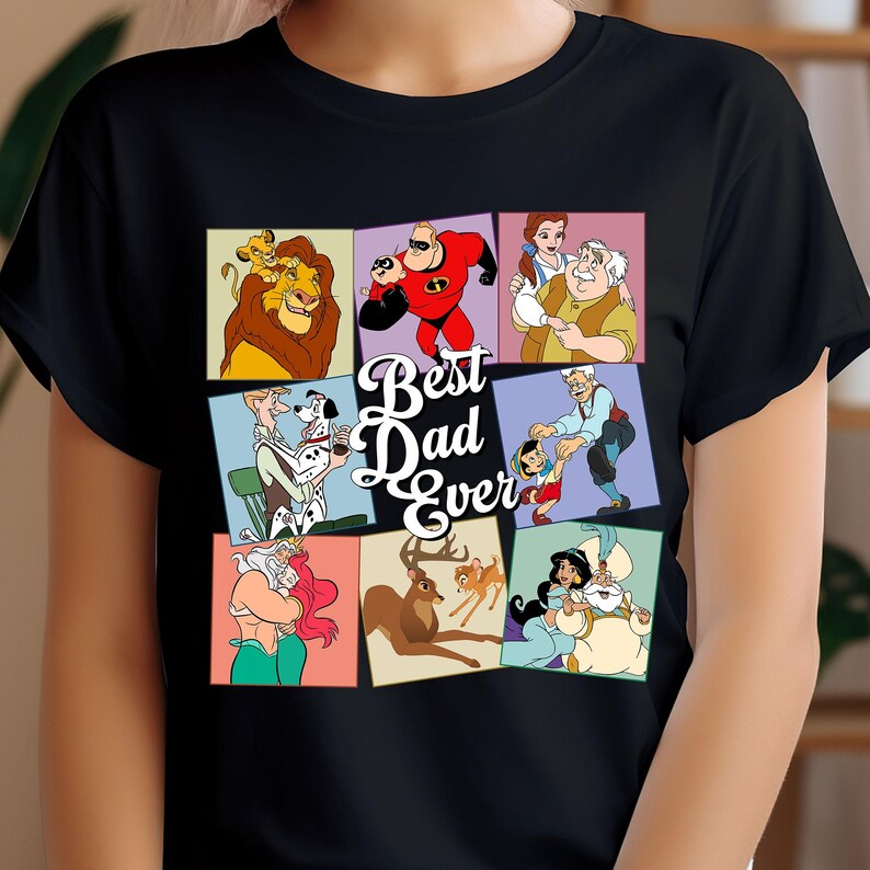 Pu&ograve; includere: T-shirt nera con un collage di personaggi dei cartoni animati e la scritta "Best Dad Ever". Il design include immagini di un leone, un supereroe e altri personaggi.