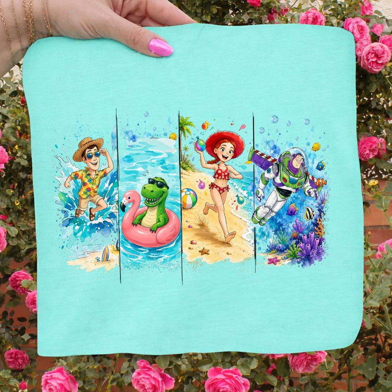 May include: A light blue t-shirt featuring a colorful beach scene. The design includes cartoon characters enjoying the beach and ocean. The characters include a man in a Hawaiian shirt, a green dinosaur in a pink float, a woman in a red bikini, and Buzz Lightyear.