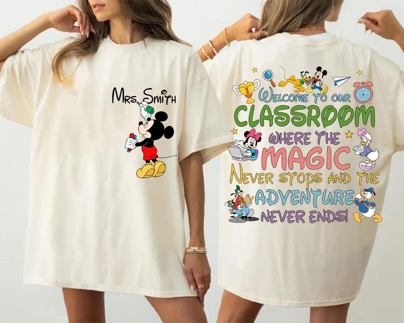 May include: Cream-colored t-shirt featuring Mickey Mouse holding a marker, with "Mrs. Smith" above. The back displays "Welcome to our Classroom" with Disney characters and the text "Where the Magic Never Stops and the Adventure Never Ends!"