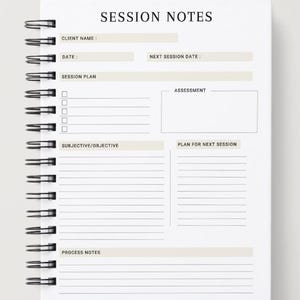 May include: A white spiral-bound notebook with the words "SESSION NOTES" at the top. The notebook has sections for client information, session plans, assessments, and notes. The design is minimalist with a clean layout.